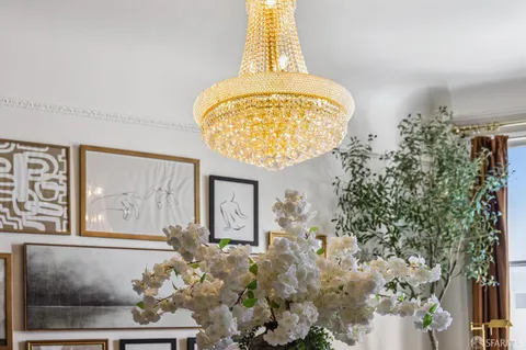a dining room with wooden floor a chandelier a wooden table and chairs