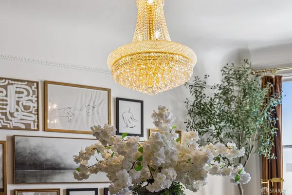 a dining room with wooden floor a chandelier a wooden table and chairs