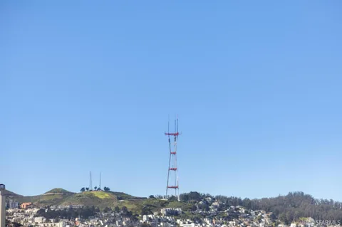 a living room with furniture potted plant and kitchen view