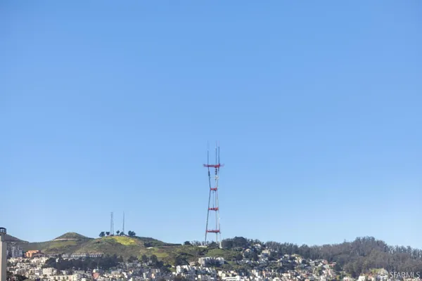 a living room with furniture potted plant and kitchen view