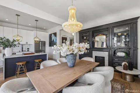 a kitchen with a dining table chairs stainless steel appliances and cabinets