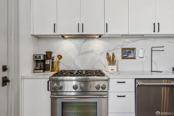 a kitchen with a refrigerator a stove a sink and a dining table