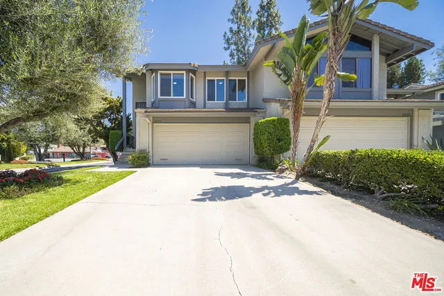 a front view of a house with a yard and potted plants
