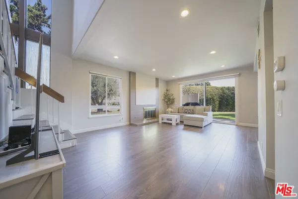 a living room with furniture and a flat screen tv with wooden floor