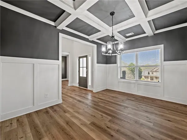 a kitchen with kitchen island granite countertop a table chairs stove and white cabinets