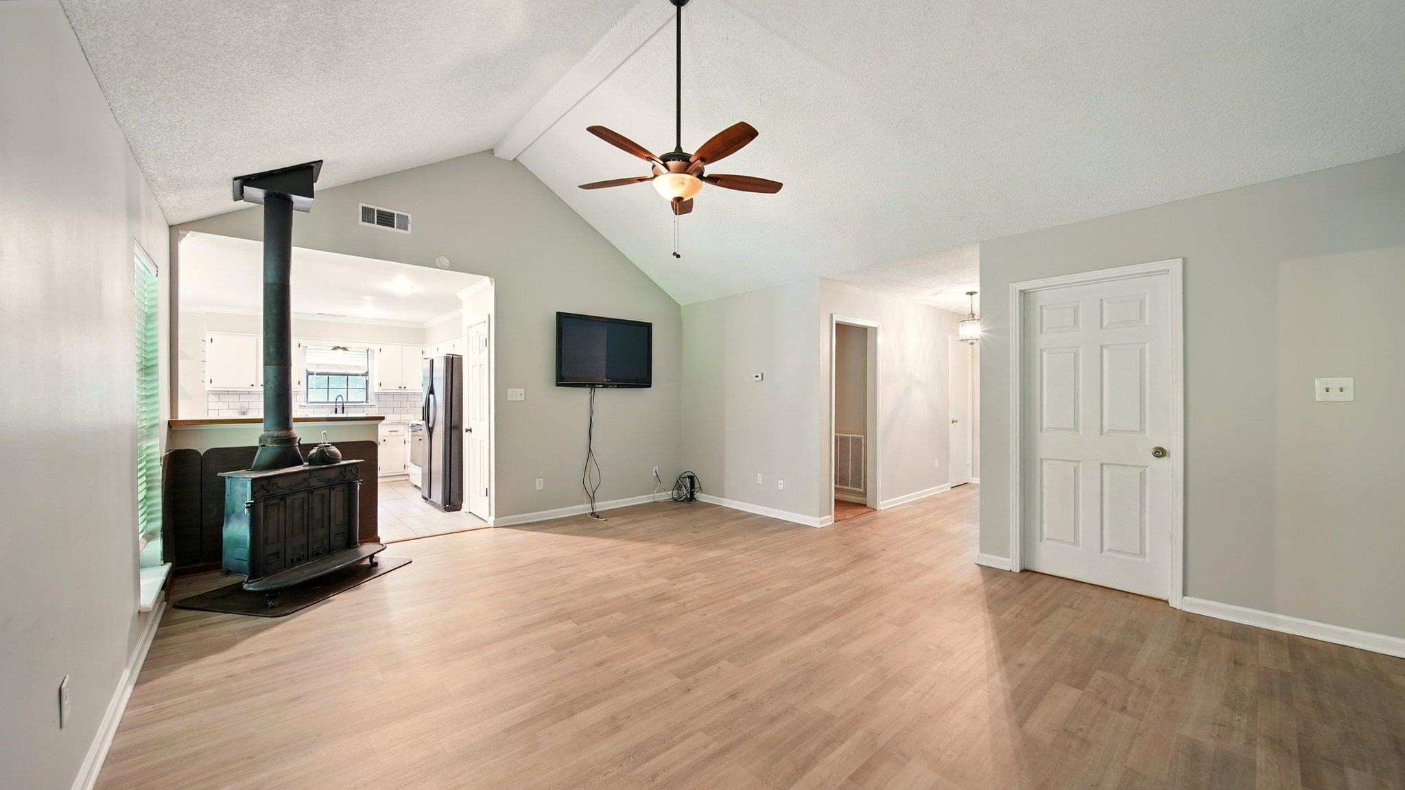 979 Ray Bluff Road Millington, TN 38053 - Photo 11 of 21 living room with a wood burning stove, ceiling fan, light wood finished floors, & vaulted ceiling