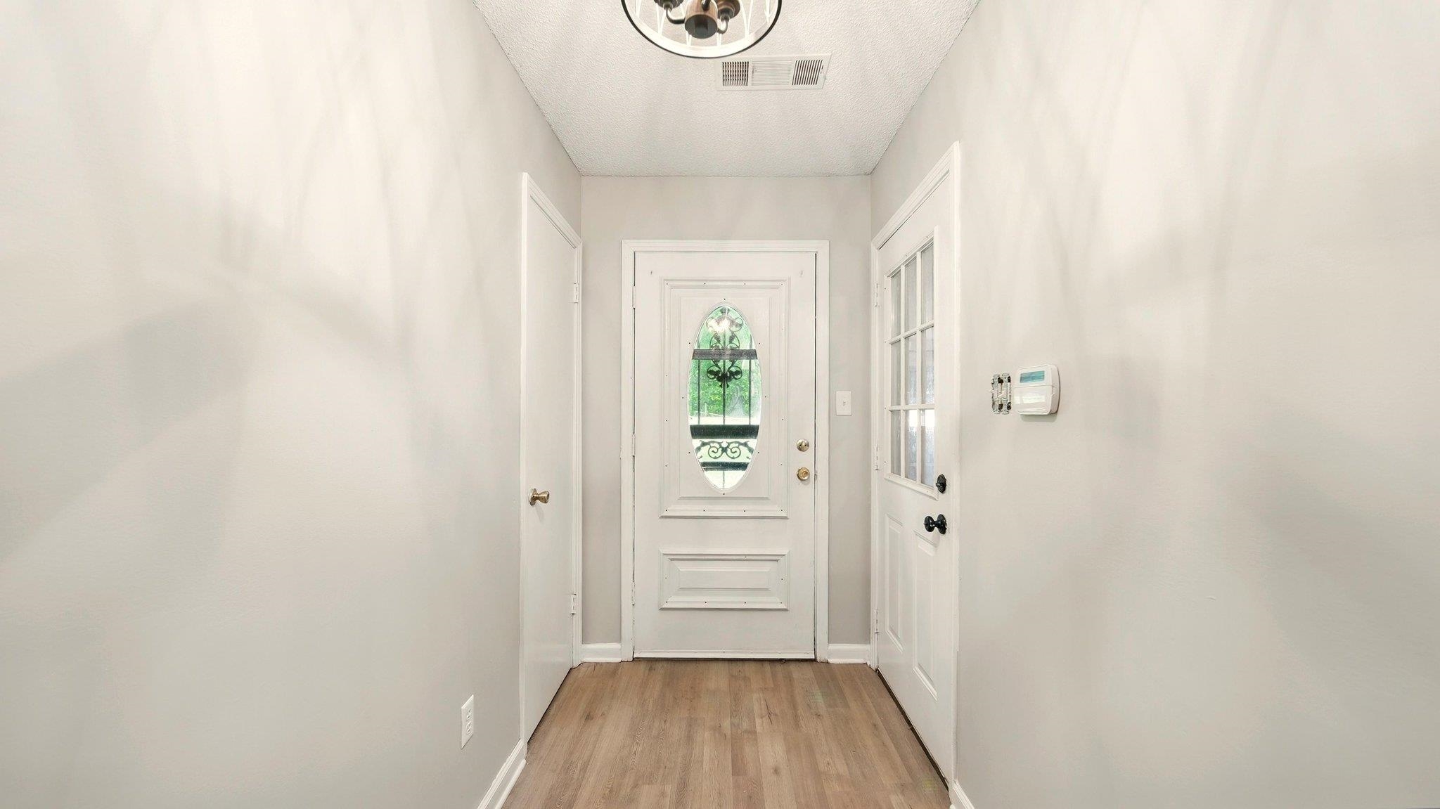 979 Ray Bluff Road Millington, TN 38053 - Photo 10 of 21 Doorway featuring light wood-type flooring, baseboards, and a textured ceiling