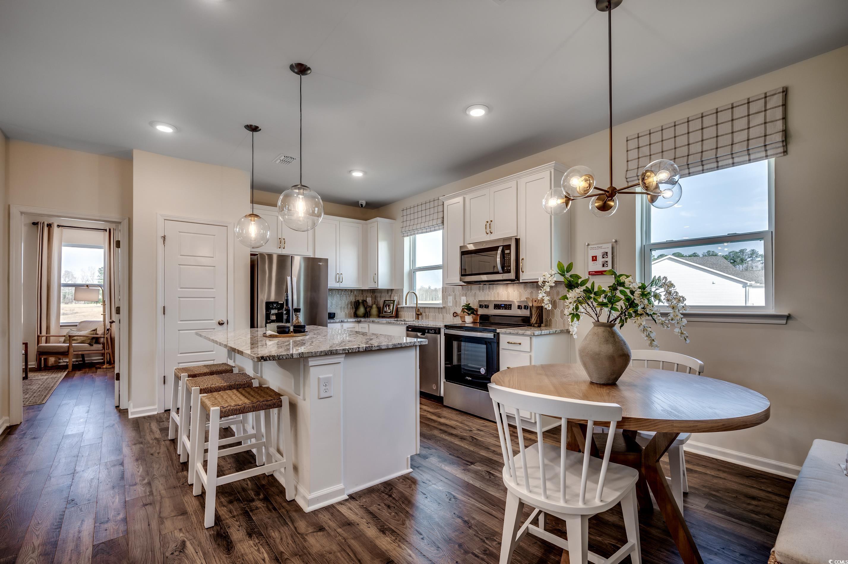 4009 Braid Court Myrtle Beach, SC 29588 - Photo 4 of 19 Kitchen featuring decorative backsplash, appliances with stainless steel finishes, a kitchen breakfast bar, white cabinets, and a center island