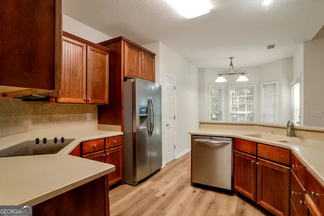 a kitchen with stainless steel appliances granite countertop a sink refrigerator and microwave