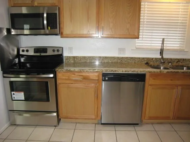 a kitchen with stainless steel appliances granite countertop a stove and a microwave
