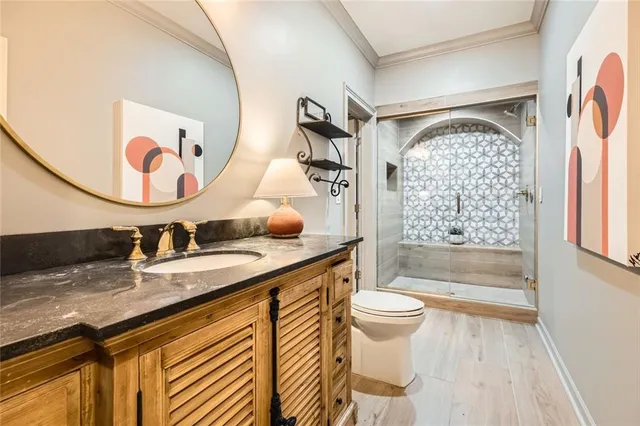 a bathroom with a granite countertop sink mirror vanity and toilet