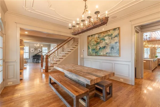 a room with wooden floor chandelier and windows