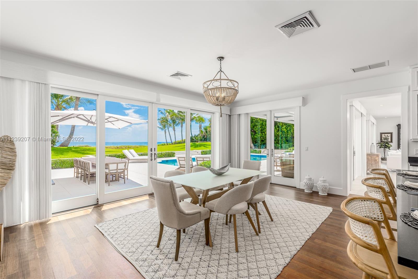 25 South Beach Road Hobe Sound, FL 33455 - Photo 18 of 34 a view of a dining room with furniture large windows and wooden floor
