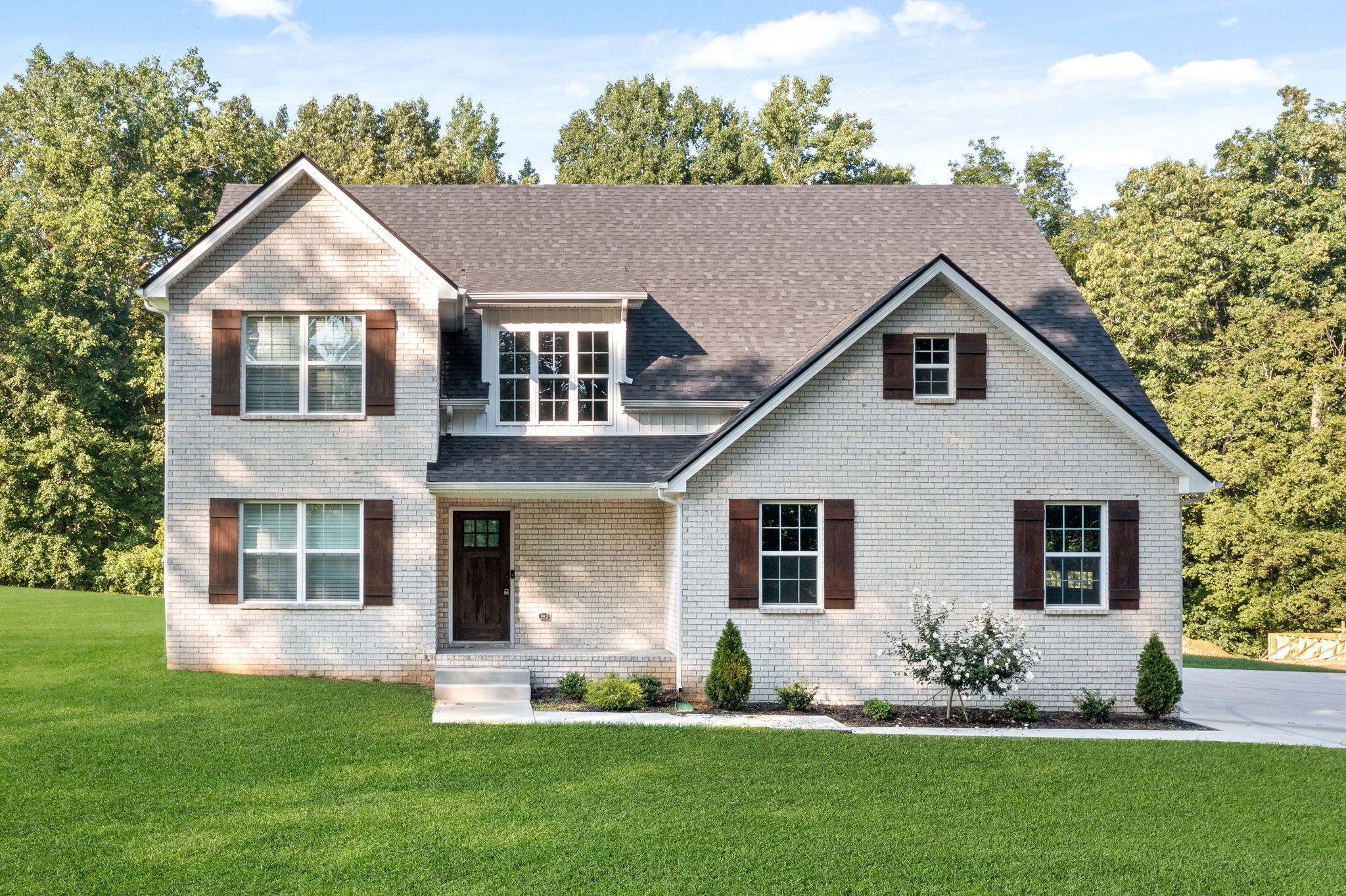 a front view of a house with a garden and plants
