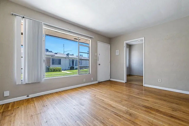 a view of an empty room with wooden floor