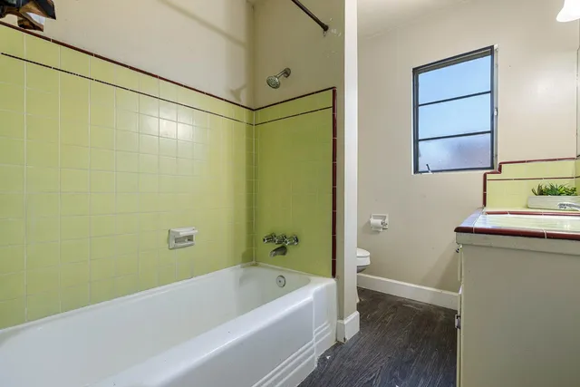 a view of an empty room with glass door and wooden floor
