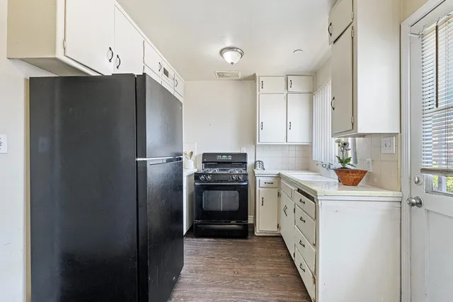 a kitchen with white cabinets and appliances