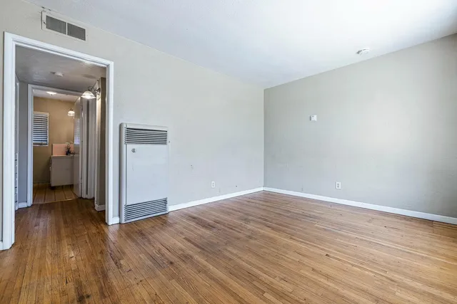 a view of an empty room with wooden floor