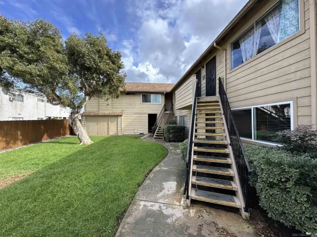 a view of a house with backyard and a tree