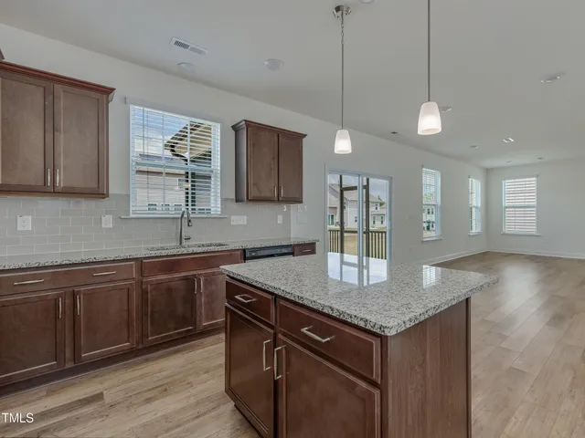 a kitchen with granite countertop cabinets a sink a window and stainless steel appliances