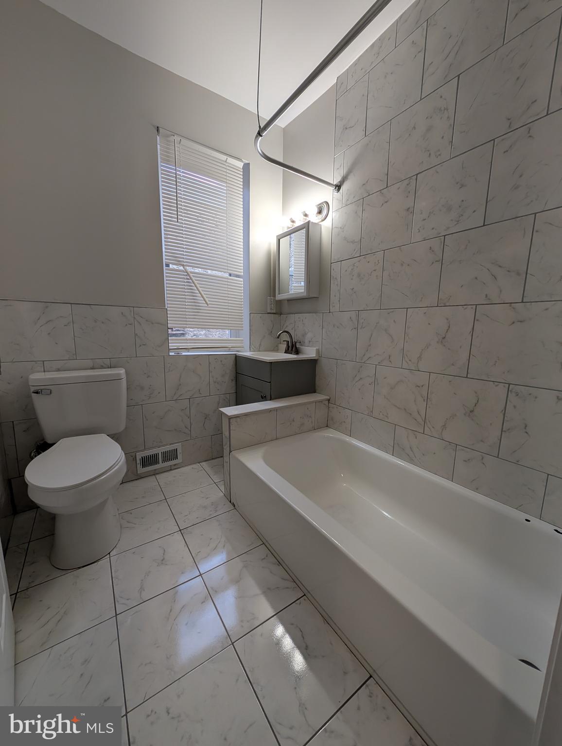 1327 North Wanamaker Street Philadelphia, PA 19131 - Photo 12 of 14 a bathroom with a bathtub and a toilet