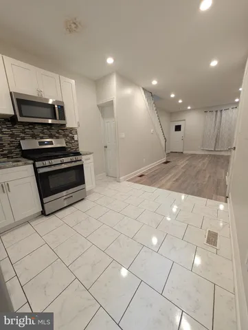 a large white kitchen with stainless steel appliances