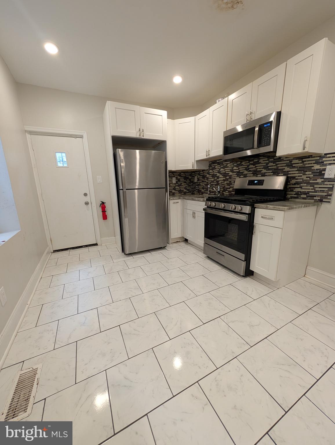 1327 North Wanamaker Street Philadelphia, PA 19131 - Photo 4 of 14 a kitchen with stainless steel appliances granite countertop a refrigerator and a sink