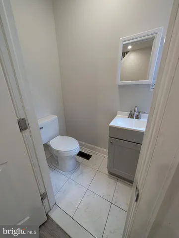 a bathroom with a sink toilet and a mirror