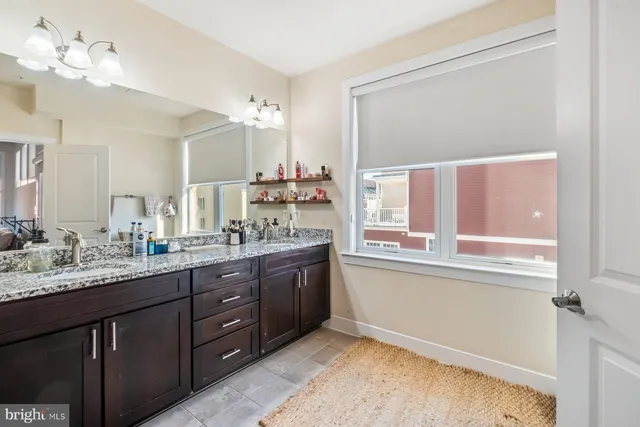 a bathroom with a granite countertop sink mirror and a bathtub