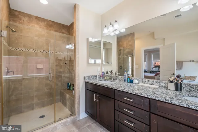 a bathroom with a granite countertop sink mirror and shower