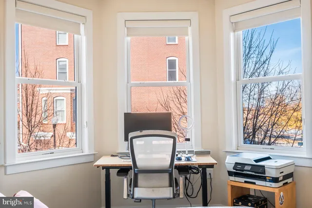 a view of a workspace with furniture and a window