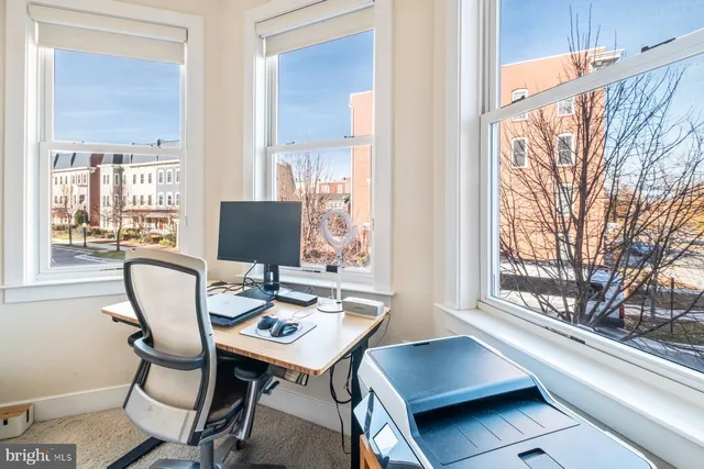 a view of a workspace with furniture and a window
