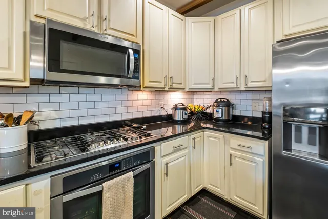 a kitchen with stainless steel appliances granite countertop a stove a microwave and cabinets
