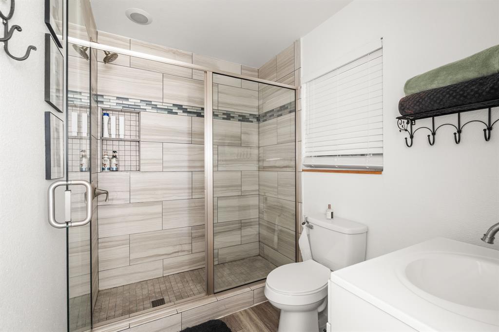 9778 Highway 11 Whitewright, TX 75491 - Photo 12 of 37 a bathroom with a shower toilet and sink