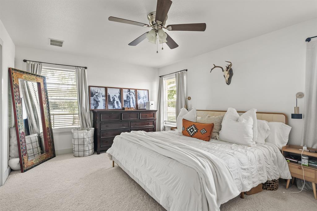 9778 Highway 11 Whitewright, TX 75491 - Photo 20 of 37 a bedroom with a bed and a chandelier