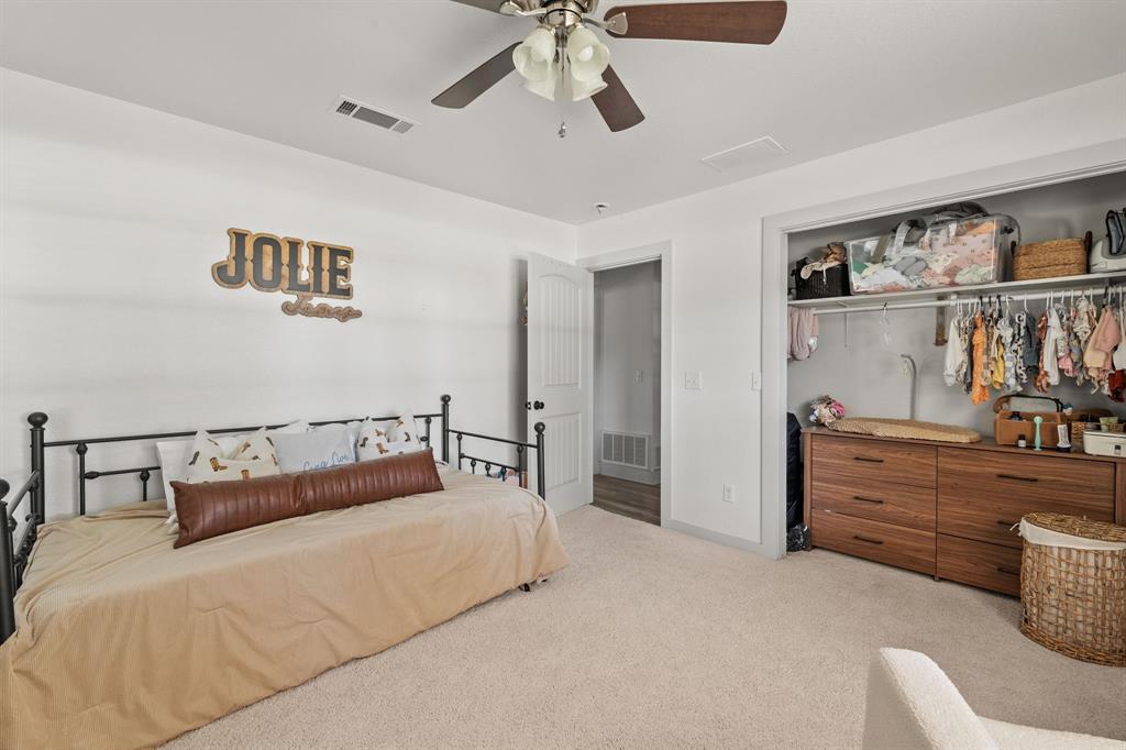 9778 Highway 11 Whitewright, TX 75491 - Photo 21 of 37 a bed room with a bed and a chandelier