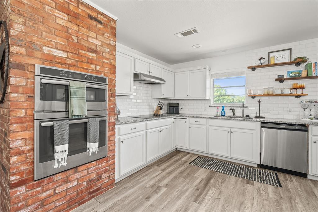 9778 Highway 11 Whitewright, TX 75491 - Photo 25 of 37 a kitchen with granite countertop white cabinets and white appliances
