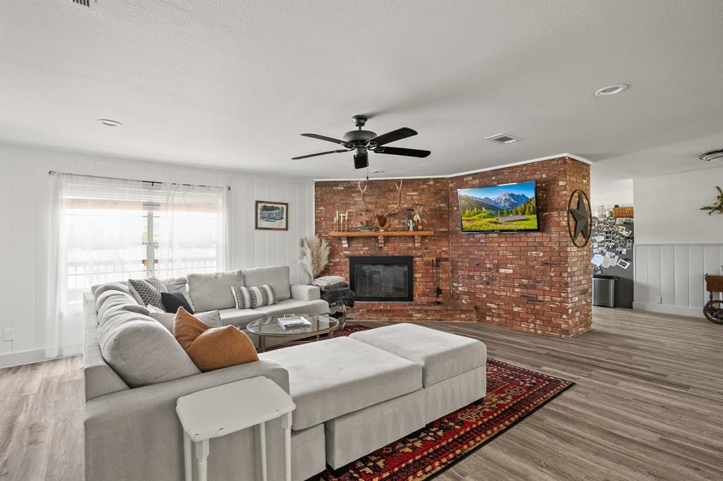 9778 Highway 11 Whitewright, TX 75491 - Photo 27 of 37 a living room with furniture a fireplace and a flat screen tv
