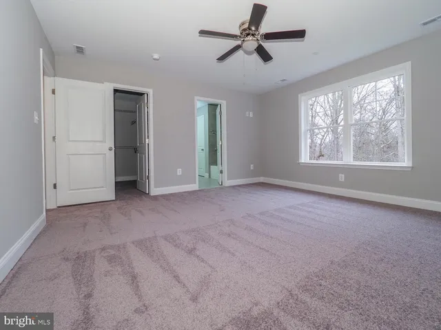 a view of a livingroom with a ceiling fan and window