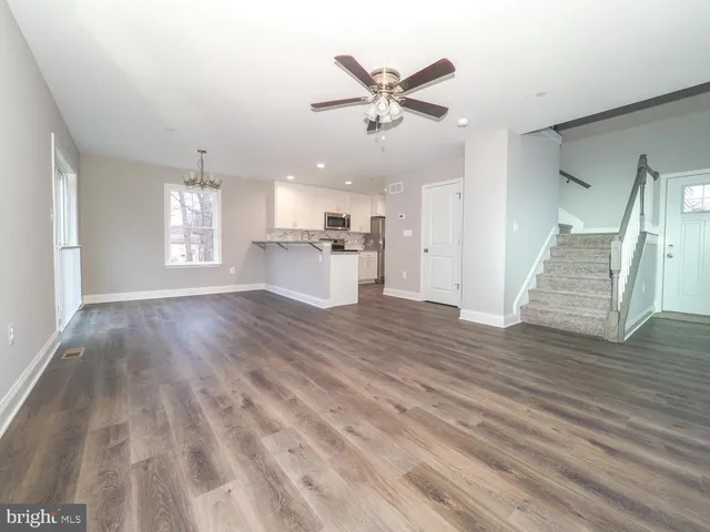 a view of a kitchen with wooden floor and a ceiling fan