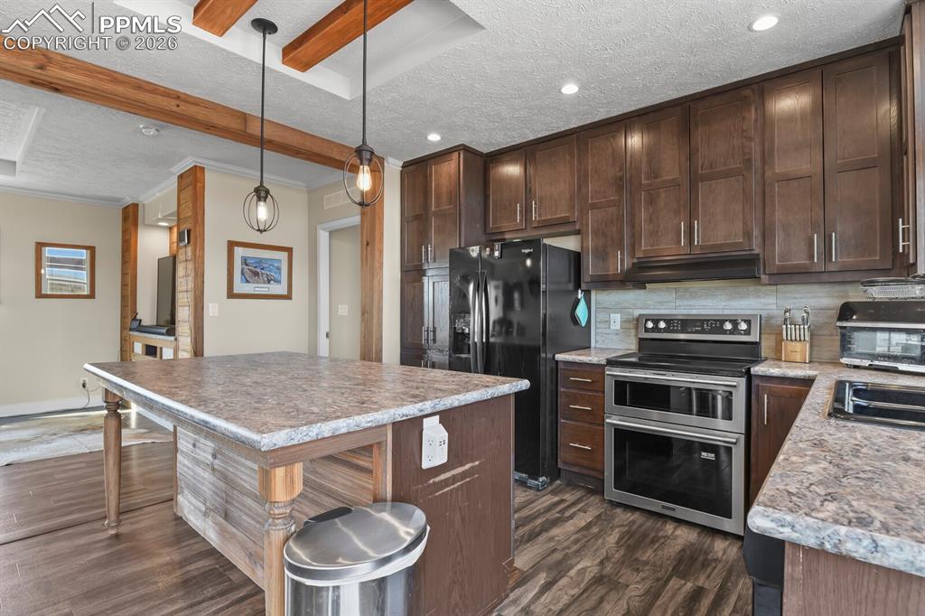 5895 Bar 10 Road Colorado Springs, CO 80928 - Photo 11 of 50 a kitchen with a stove a refrigerator and a stove