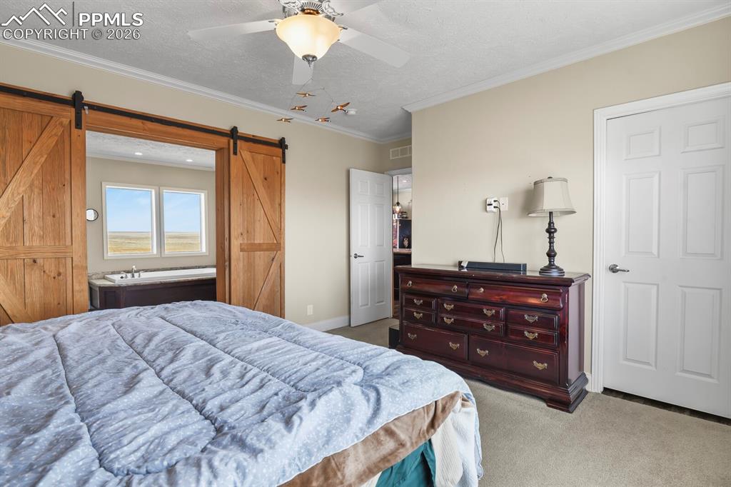 5895 Bar 10 Road Colorado Springs, CO 80928 - Photo 13 of 50 a bedroom with a bed and a dresser
