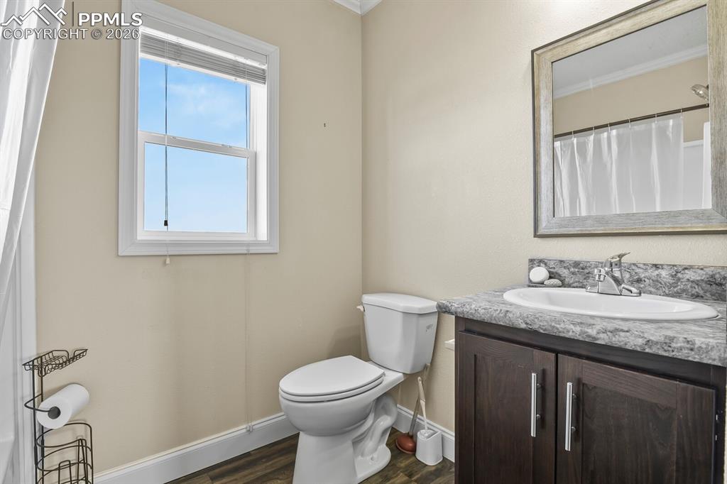 5895 Bar 10 Road Colorado Springs, CO 80928 - Photo 20 of 50 a bathroom with a granite countertop toilet sink and mirror