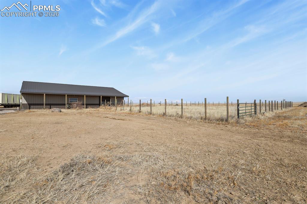 5895 Bar 10 Road Colorado Springs, CO 80928 - Photo 26 of 50 a view of a house with a yard and sitting area