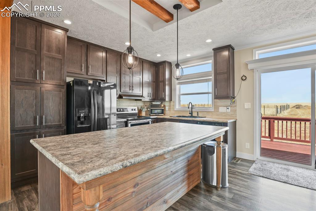 5895 Bar 10 Road Colorado Springs, CO 80928 - Photo 8 of 50 a kitchen with kitchen island a counter space a sink appliances and cabinets
