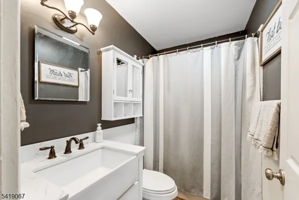 a bathroom with a sink vanity mirror and toilet