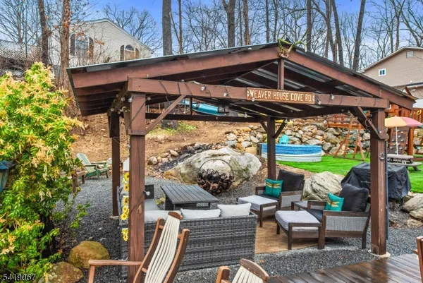 a view of a chairs and table in patio with a barbeque grill
