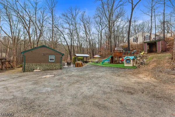 a view of a house with a yard and large trees