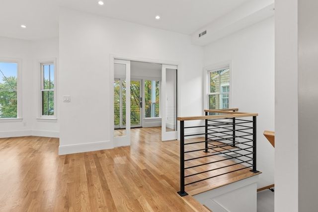 a view of a hallway with wooden floor and windows