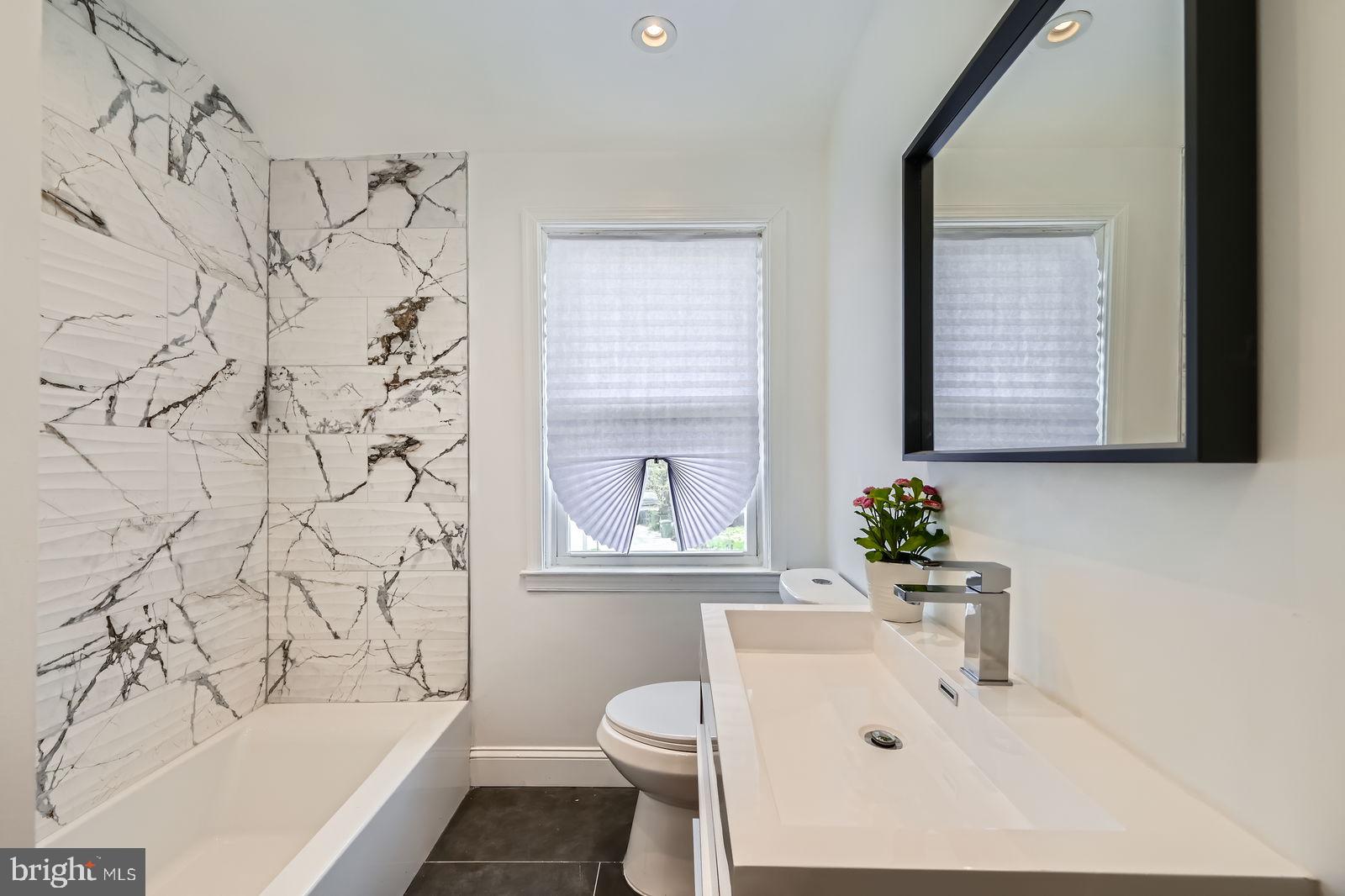 6200 Falkirk Road Baltimore, MD 21239 - Photo 17 of 27 a bathroom with a bathtub sink mirror and toilet
